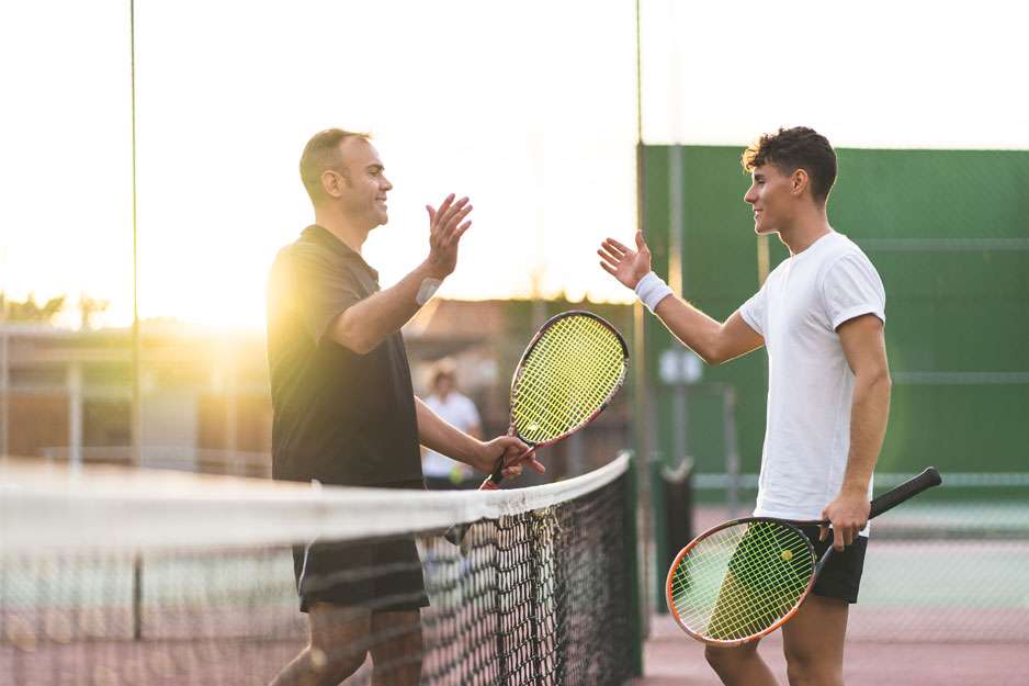 Two healthy men playing tennis
